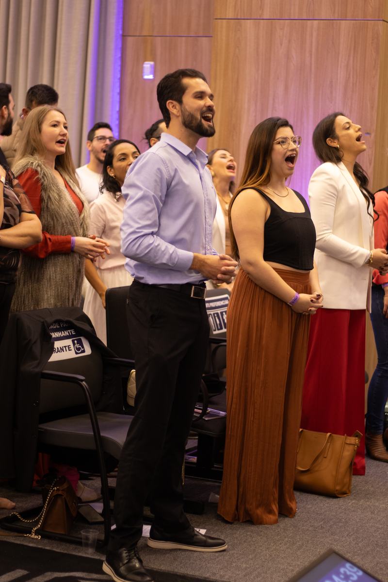 Participantes de pé cantando juntos
