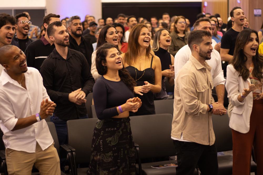 Plateia de congresso de pé, batendo palmas