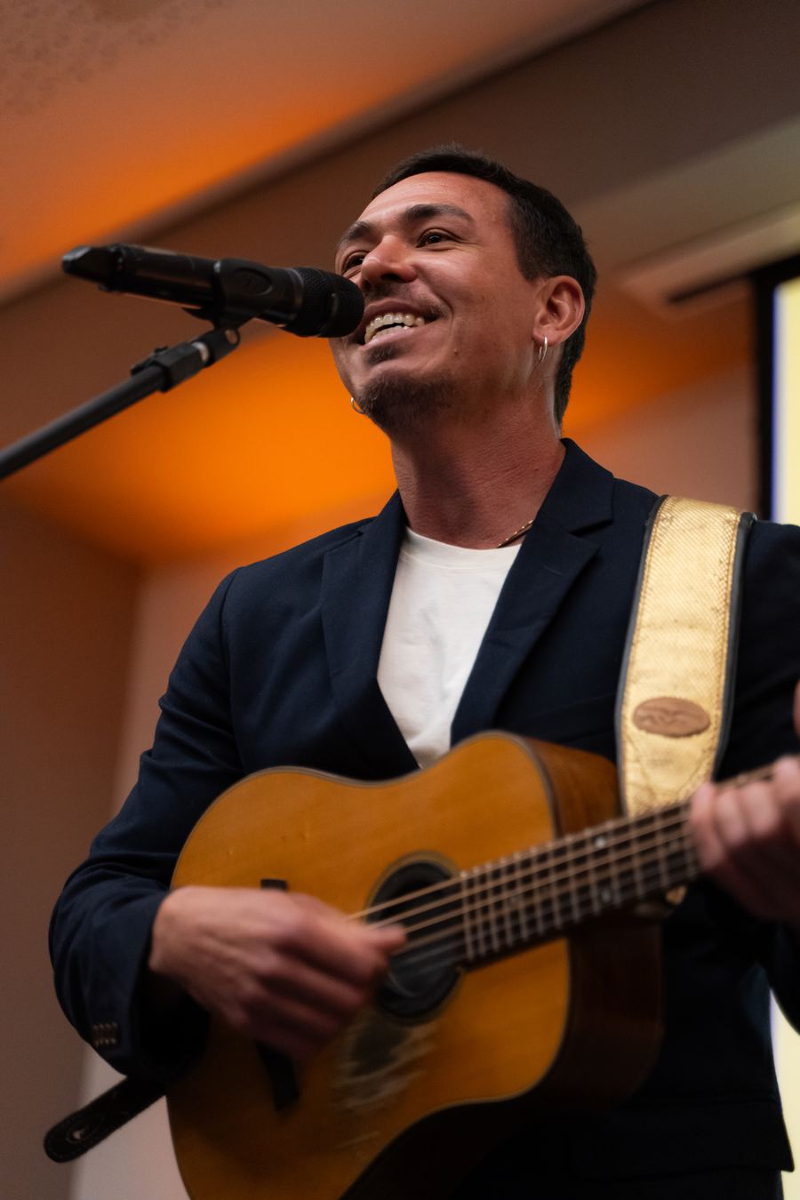 Diôgo Mar de blazer, cantando com o violão