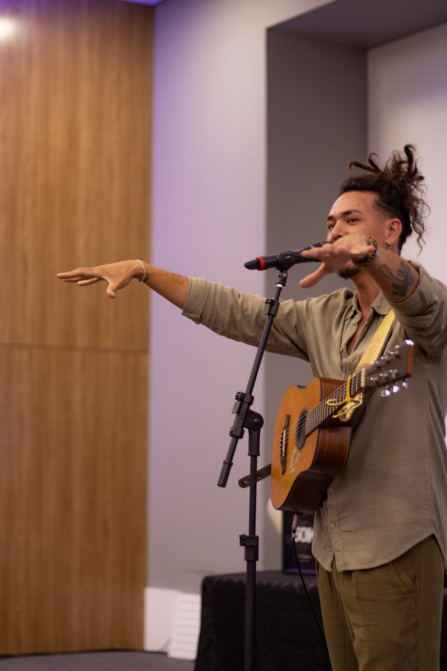 Diôgo com o violão, apontando para a plateia enquanto conduz